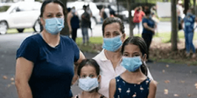 A family of four wearing masks